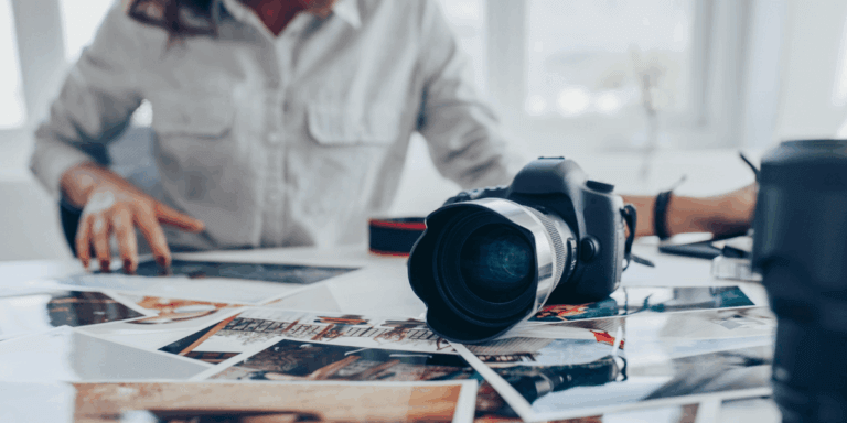 a person with a desk of photos and a camera
